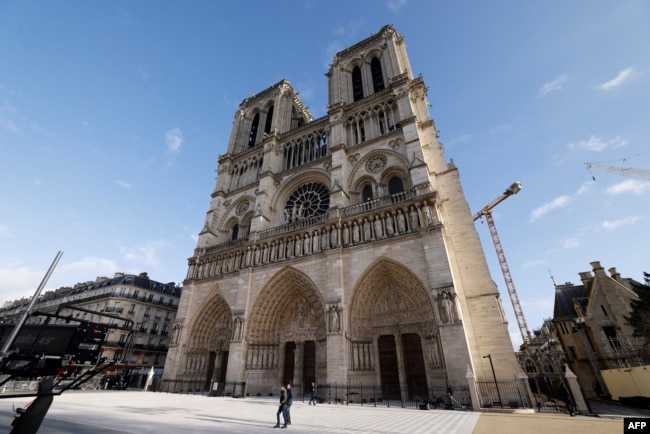 La gente camina frente a la catedral de Notre-Dame de París, antes de su ceremonia de reapertura oficial después de más de cinco años de trabajos de reconstrucción tras el incendio de abril de 2019, en París el 7 de diciembre de 2024.