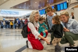 Gidget McBurnett greets her grandchildren and her daughter Whitney after the family landed in Atlanta ahead of the Thanksgiving holiday at Hartsfield-Jackson Atlanta International Airport in Atlanta, Georgia, U.S. Nov. 22, 2022.