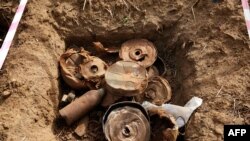 FILE - Landmines and debris from historic fighting are seen during the bomb disposal in Jebel Lemuni, 15km south of Juba, South Sudan, on January 30, 2019.