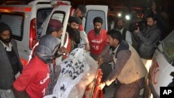 Pakistani volunteers carry the body of a militant killed during a crackdown by security forces in Quetta, Dec. 19, 2014.