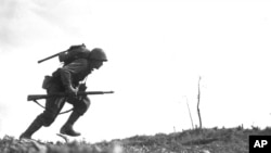 Pfc. Paul Ison, a U.S. Marine runs through Japanese gunfire on Okinawa, May 10, 1945.