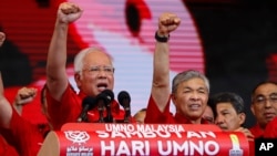 Malaysian Prime Minister and President of Malaysia's ruling party United Malays National Organization's (UMNO) Najib Razak (left) and Deputy Prime Minister Ahmad Zahid Hamidi chant a slogan during a celebration of party's 71st anniversary in Kuala Lumpur,