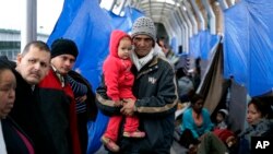 FILE - Families hoping to seek asylum in the United States wait on the bridge connecting Reynosa, Mexico, to Hidalgo, Texas, March 15, 2019.