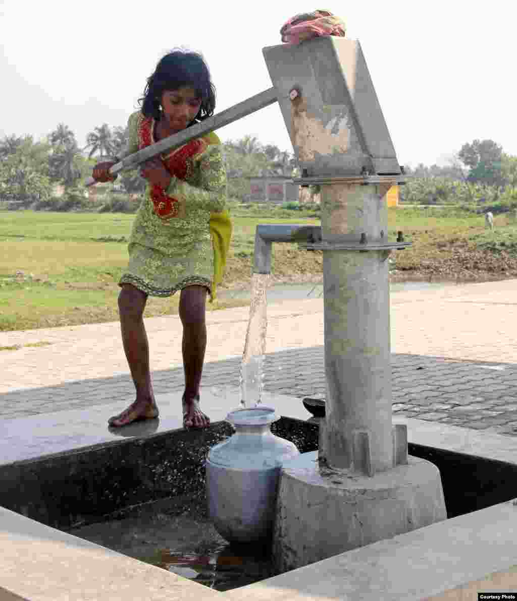 A little village girl fills drinking water in a pot at Uttar Radhanagar Railway Station of South24 Pargana district, West Bengal, India, Feb. 28, 2013. (Photo by Chandan Ghosh/India/VOA reader) 
