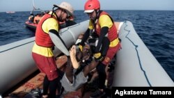 Les membres de l'ONG humanitaire espagnole Proactiva Open Arms, portent le cadavre d'un migrant après une opération de sauvetage au large des côtes libyennes le 4 octobre 2016.