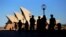 FILE - People walk in front of the Sydney Opera House, Australia, Nov. 2, 2016.