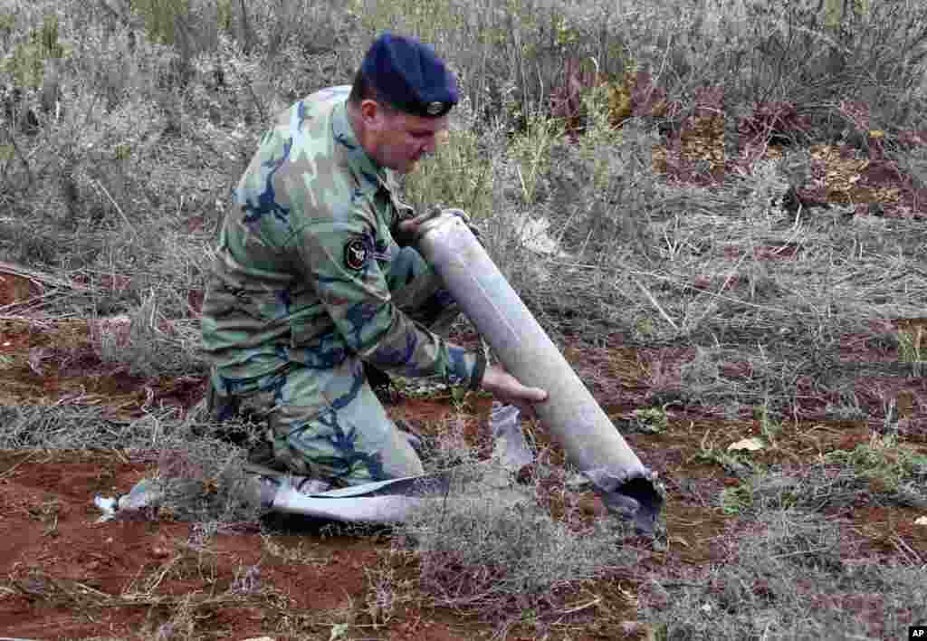 A Lebanese army soldier holds the remains of a rocket, Sarada, Lebanon, Dec. 29, 2013.