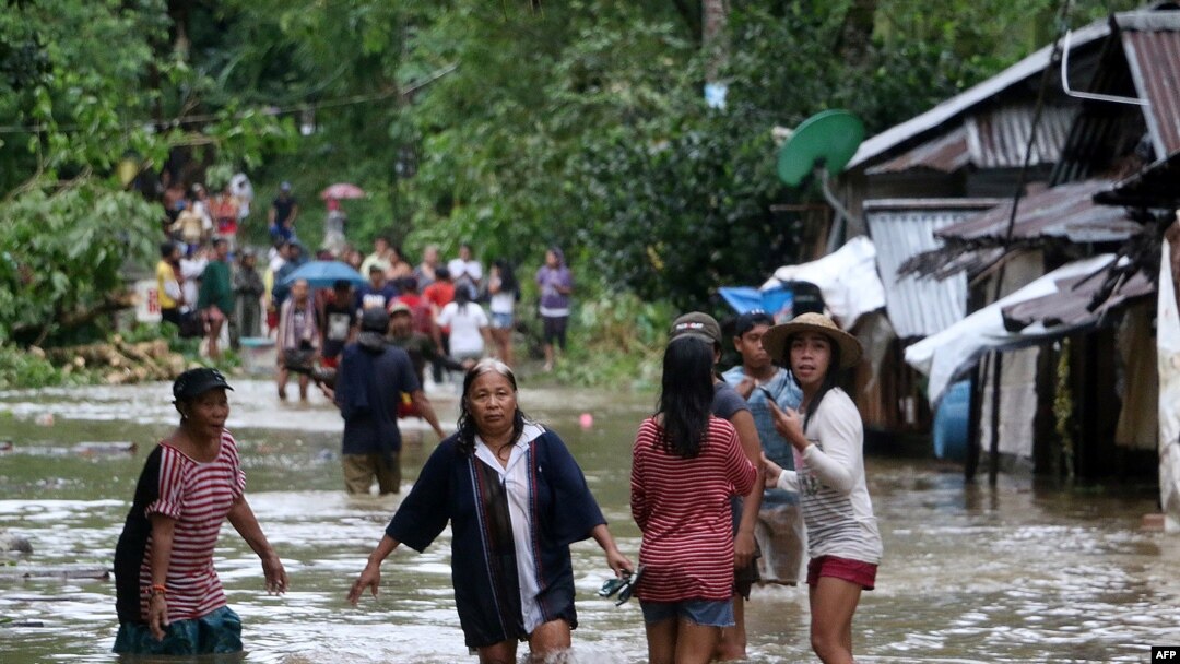Warga di tengah banjir di Brgy Calingatngan, di Borongan, Samar timur, Filipina tengah, 16 Desember 2017.