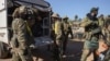 Syrian opposition fighters get off a truck as they enter the village of Anjara, on the western outskirts of Aleppo, Nov. 28, 2024, as part of their major offensive on government-controlled areas in the country's northwest.