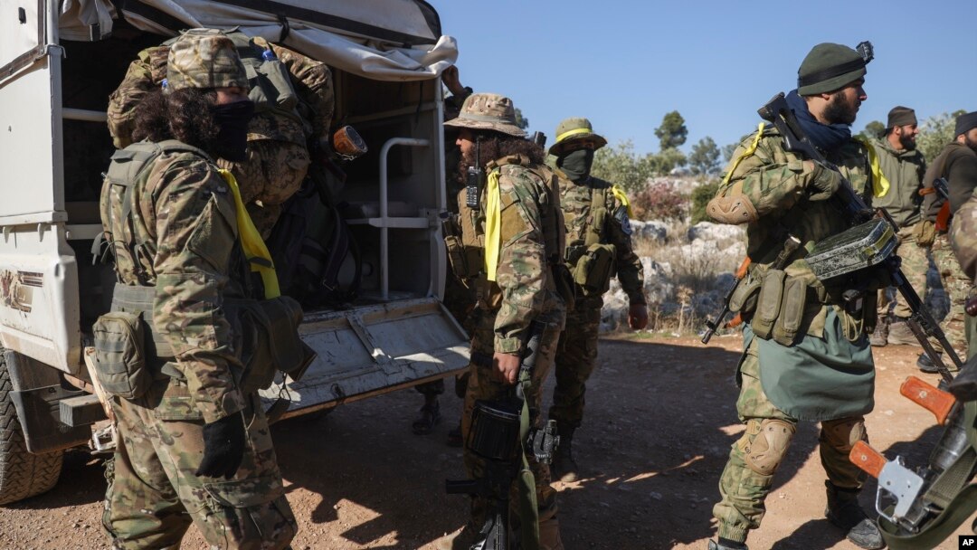 Syrian opposition fighters get off a truck as they enter the village of Anjara, western outskirts of Aleppo, Nov. 28, 2024, part of their major offensive on government-controlled areas in the country's northwestern.