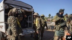 Syrian opposition fighters get off a truck as they enter the village of Anjara, western outskirts of Aleppo, Nov. 28, 2024, part of their major offensive on government-controlled areas in the country's northwestern.