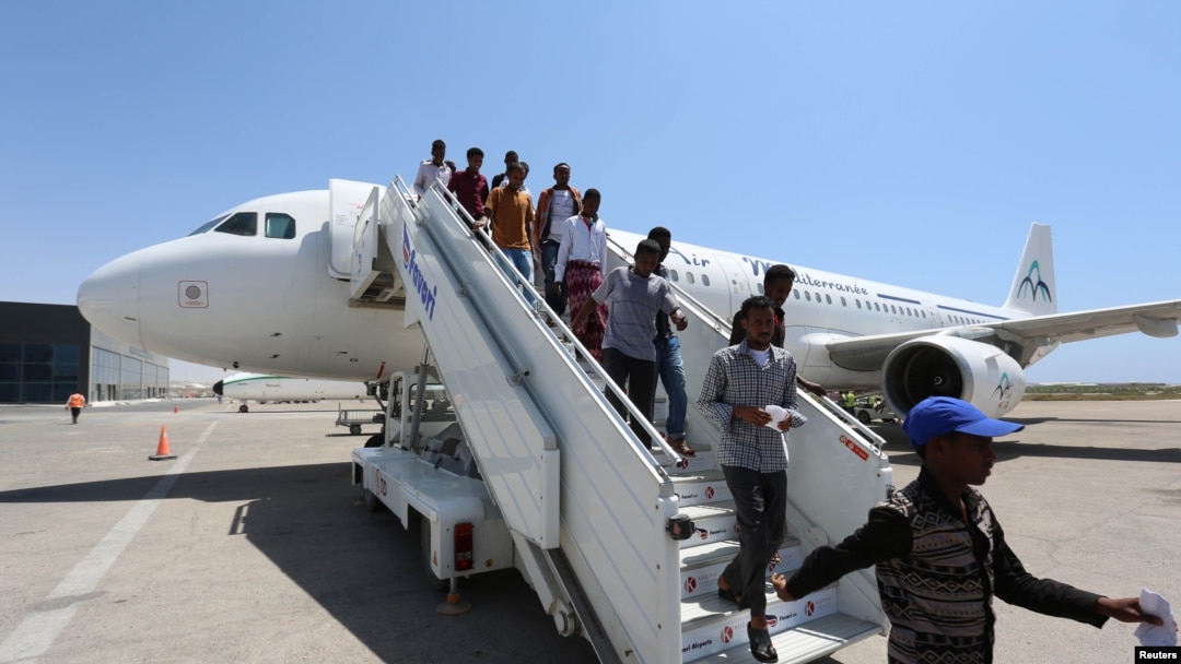 Daallo Airlines staff usher in passengers from Jeddah after their airline, Daallo Airlines operated by Air Mediterranee, arrived at the Aden Abdule International Airport in Somalia's capital Mogadishu, February 17, 2015.
