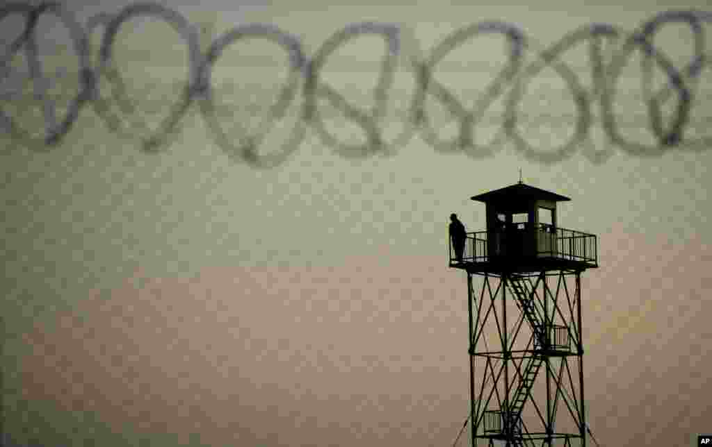 A man watches from a border tower in Serbia near the Hungarian village Roszke, southern Hungary, Sept. 12, 2015. Hundreds of thousands of Syrian refugees and others are still making their way slowly across Europe, seeking shelter where they can, taking a bus or a train where one is available, walking where it isn&#39;t.