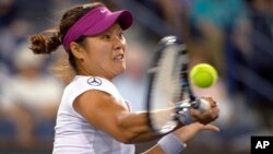 Li Na, de China, regresa la bola a Aleksandra Wozniak, de Canadá.