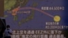 Orang-orang berjalan di depan layar yang menampilkan laporan berita tentang Korea Utara yang menembakkan rudal balistik di atas Jepang, di Tokyo, Jepang, 4 Oktober 2022. (Foto: REUTERS/Issei Kato)