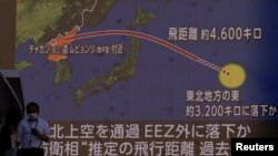 Orang-orang berjalan di depan layar yang menampilkan laporan berita tentang Korea Utara yang menembakkan rudal balistik di atas Jepang, di Tokyo, Jepang, 4 Oktober 2022. (Foto: REUTERS/Issei Kato)