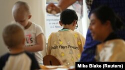 Pasien kanker anak-anak di Rumah Sakit Anak Rady berpartisipasi dalam mendekorasi jubah emas bertuliskan "Unleash Your Power" untuk dikenakan sebagai bagian dari Bulan Kanker Anak di San Diego, California, AS, 4 September 2019. (Foto: REUTERS/Mike Blake)