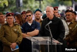 FILE - Israeli Defense Minister Yoav Gallant speaks at a ceremony for soldier Colonel Asaf Hamami, who was killed defending Kibbutz Nirim during the deadly October 7 attack by Palestinian Islamist group Hamas, at his funeral in Tel Aviv, Israel December 4, 2023.