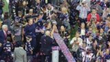 Patriots quarterback Tom Brady, center, holds up Vince Lombardi trophy after defeating the Atlanta Falcons in Superbowl 51 in Houston, Texas, Feb. 5, 2016. (Photo: B. Allen / VOA) 