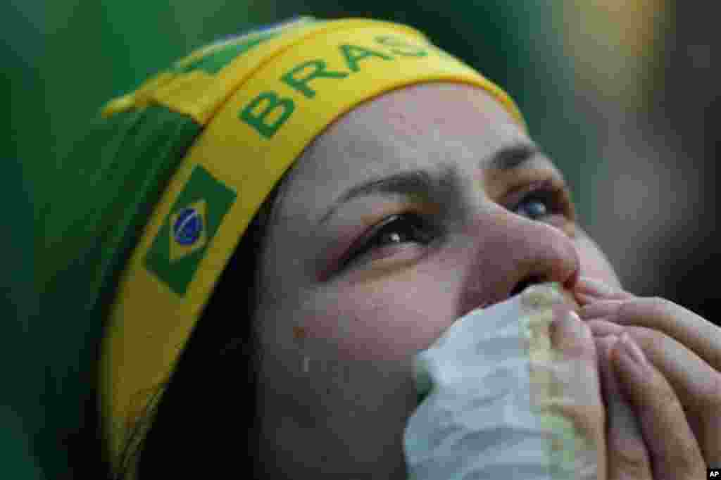 A fan of Brazil cries as she watches as the Netherlands scores a second goal against Brazil, during the match for the third place finish of the World Cup, at the FIFA Fan Fest in Sao Paulo, Brazil, Saturday, July 12, 2014. (AP Photo/Dario Lopez-Mills)