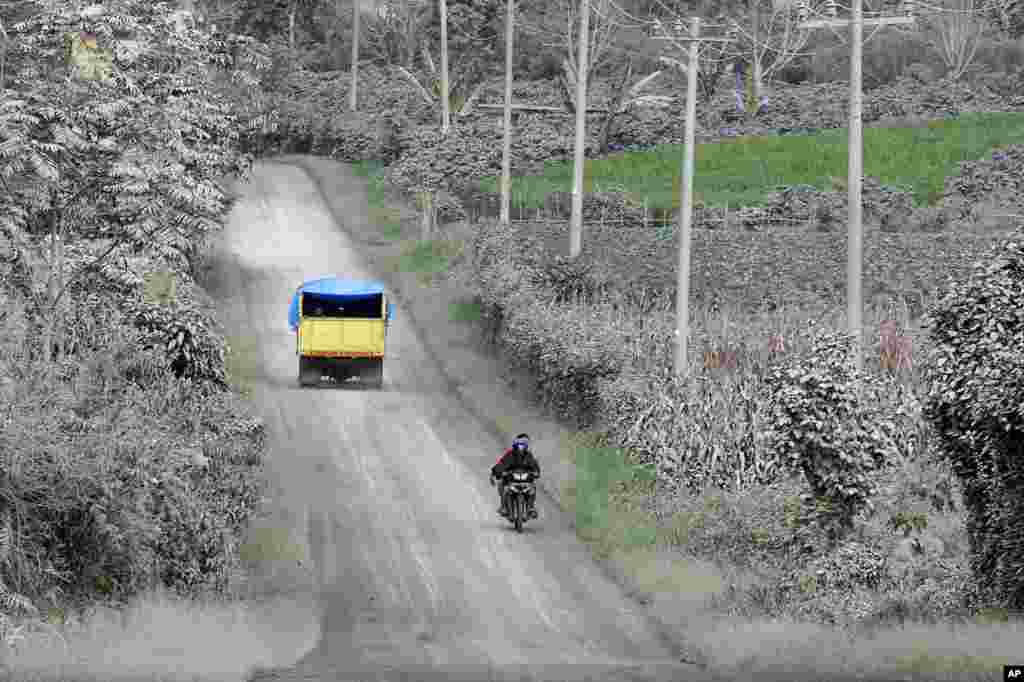 Motorists ride on a road covered by volcanic ash from the eruption of Mount Sinabung in Karo, North Sumatra, Indonesia.