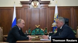 Russia's President Vladimir Putin and Defense Minister Sergei Shoigu attend a meeting to discuss a recent incident with a Russian deep-sea submersible, which caught fire in the area of the Barents Sea, in Moscow, July 2, 2019. 