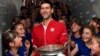 Serbia's Novak Djokovic is cheered by ball girls after defeating Britain's Andy Murray in their final match of the French Open tennis tournament at the Roland Garros stadium, June 5, 2016 in Paris.