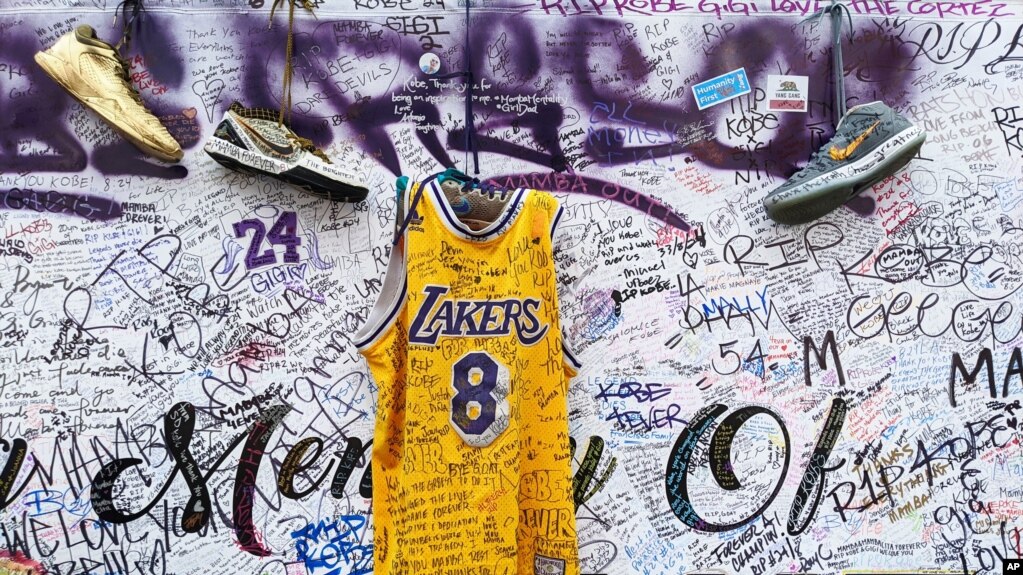 Sneakers and a Los Angeles Lakers jersey with the number 8 worn by NBA star Kobe Bryant hang at a memorial for Bryant in Los Angeles, Feb. 2, 2020, a week after he was killed in a helicopter crash. 