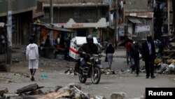 A motorcyclist drives through obstacles placed on a street by supporters of opposition leader Raila Odinga during the latest protests in Mathare, Nairobi, Kenya, August 14, 2017. 