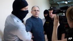Paul Whelan, mantan anggota marinir AS (kedua dari kiri), yang ditahan dengan tuduhan mata-mata di Moskow pada akhir 2018, dikawal oleh anggota Dinas Keamanan Federal Rusia, memasuki ruang sidang di pengadilan di Moskow, Rusia, 23 Agustus 2019.