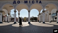 An elderly woman walks at the main railway station in Simferopol, Ukraine, Friday, March 14, 2014