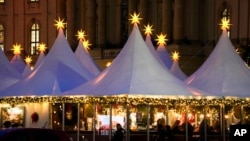 Christmas stars illuminate the top of the tents of the Christmas market at Bebelplatz in Berlin, Nov. 25, 2024.