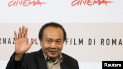 Cambodian director Rithy Panh waves as he poses during a photo call, Oct. 24, 2008 (File)