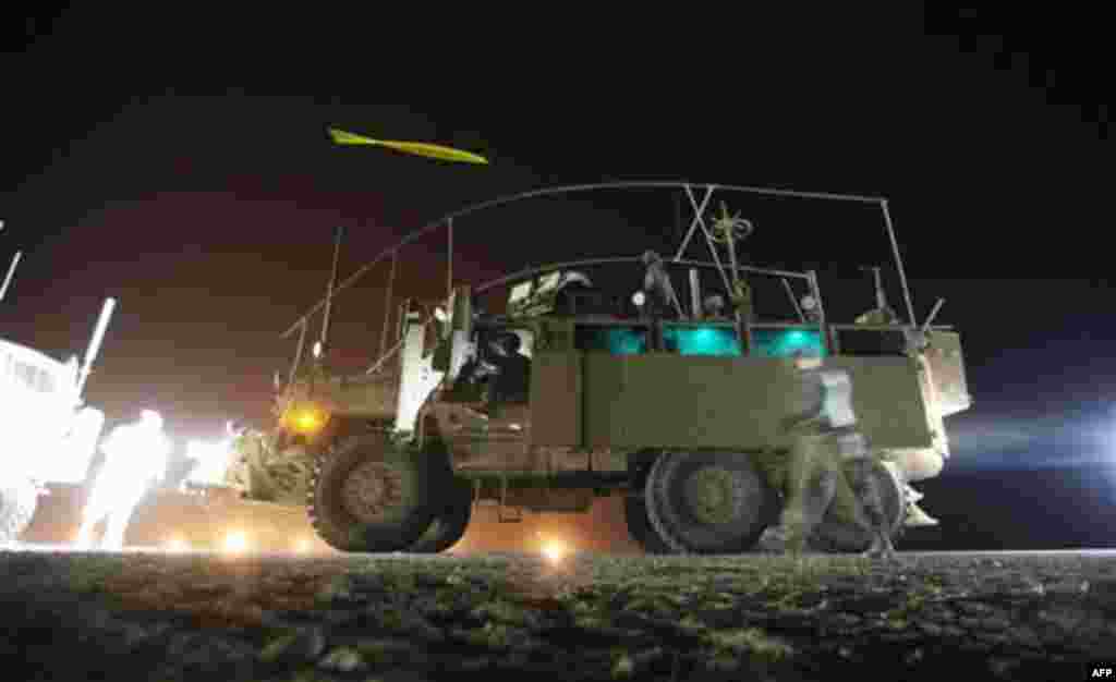 CORRECTS DATE TO FRIDAY - In this Friday, Dec. 16, 2011 photo, soldiers from the 3rd Brigade Combat Team, 1st Cavalry Division throw chemical lights at each other outside a Mine Resistant Ambush Protected (MRAP) vehicle after returning from the U.S. milit