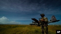 FILE - U.S. Army Spc. Kevin Martin, assigned to the 1-186th Infantry Battalion, provides security for a 75th Expeditionary Airlift Squadron plane during unloading operations at an unidentified location in Somalia, June 28, 2020.