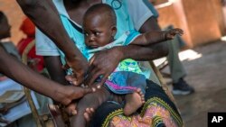 FILE- A baby from the Malawi village of Tomali is injected with the world's first vaccine against malaria in a pilot program, in Tomali, Dec. 11, 2019. 