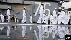 FILE - Crew of the U.S. navy aircraft carriers USS Ronald Reagan rig a ship for the voyage at the US navy's Yokosuka base, May 16, 2024, in Yokosuka, south of Tokyo. This is the ship's final departure from Yokosuka before transiting back to the US.