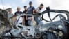 Palestinians inspect a vehicle damaged in an Israeli airstrike near Tulkarm in the Israeli-occupied West Bank on Aug. 3, 2024. 