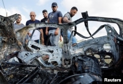 Palestinians inspect a vehicle damaged in an Israeli airstrike, in Zeita, near Tulkarm, in the Israeli-occupied West Bank, Aug. 3, 2024.