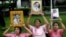 Thais hold portraits of Thai King Bhumibol Adulyadej at Siriraj Hospital where the king is being treated in Bangkok, Thailand, Oct. 11, 2016. 