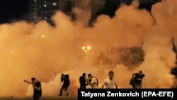 На фото: протестувальники тікають від сльозогінного газу у Мінську 9-го серпня