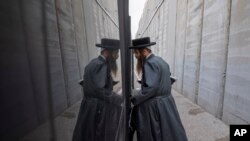 An Ultra Orthodox Jewish man gets on a bus near by the concrete barrier built by Israel to secure the Rachel&#39;s Tomb Judaism&#39;s third holiest shrine, during an annual mass prayer that drew tens of thousands of worshippers to commemorate the Jewish Matriarch Rachel, in the west bank town of Bethlehem.
