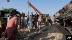 Railway workers rebuild the track at the site of a train collision in the Ghotki district, southern Pakistan, June 8, 2021. 