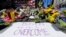 FILE - Flowers and signs adorn a barrier, two days after two explosions killed three and injured hundreds, at Boylston Street near the of finish line of the Boston Marathon at a makeshift memorial for victims and survivors, April 17, 2013. 