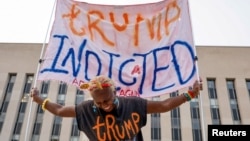 Nadine Seiler holds a sign in front of the federal courthouse where former U.S. President Donald Trump is expected later this week to answer charges in the investigation of efforts to overturn his 2020 election defeat In Washington, U.S. August 1, 2023. (REUTERS/Jonathan Ernst)