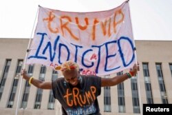 Nadine Seiler memegang spanduk di depan gedung pengadilan federal tempat mantan Presiden AS dan kandidat presiden dari Partai Republik Donald Trump diharapkan akhir pekan ini di Washington, AS, 1 Agustus 2023. (Foto: REUTERS/Jonathan Ernst)