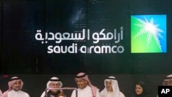 FILE - In this Dec. 11, 2019 photo, Saudi Arabia's state-owned oil company Aramco and stock market officials celebrate the debut of Aramco's initial public offering on the Riyadh Stock Market, in Riyadh, Saudi Arabia. 