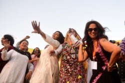 FILE - Activists of the Aurat March celebrate as they gather during a rally to mark International Women's Day in Karachi, March 8, 2021.