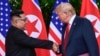 Kim Jong Un, dirigeant de la Corée du Nord, et Donald Trump, président des États-Unis, se serrent la main à l'issue de leur réunion au complexe Capella de l'île de Sentosa, le 12 juin 2018 à Singapour.