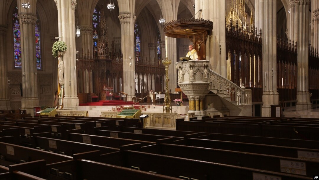 Archbishop Timothy Dolan delivers his homily over empty pews as he leads an Easter Mass at St. Patrick's Cathedral in New York, Sunday, April 12, 2020.